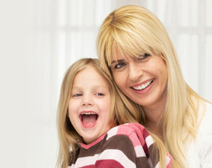 Smiling with beautiful glowing teeth mother and daughter.
